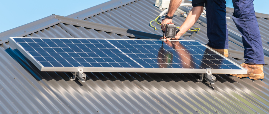 Unidentified man attaching solar panel to the roof rack