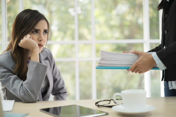 Office Lady feeling bored with giving stack of paperwork from manager