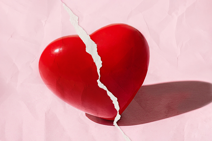 Red broken Heart on pastel pink color with Torn Paper Effect. Valentine's Day, Love, concept. Close up. Copy space.