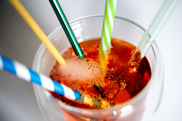 ILLUSTRATION - 01 October 2021, Lower Saxony, Oldenburg: A glass of lemonade with several reusable drinking straws made of paper, stainless steel, hard plastic and glass as well as a macaroni (2nd from left) used as a drinking straw stands on a table. (to dpa 